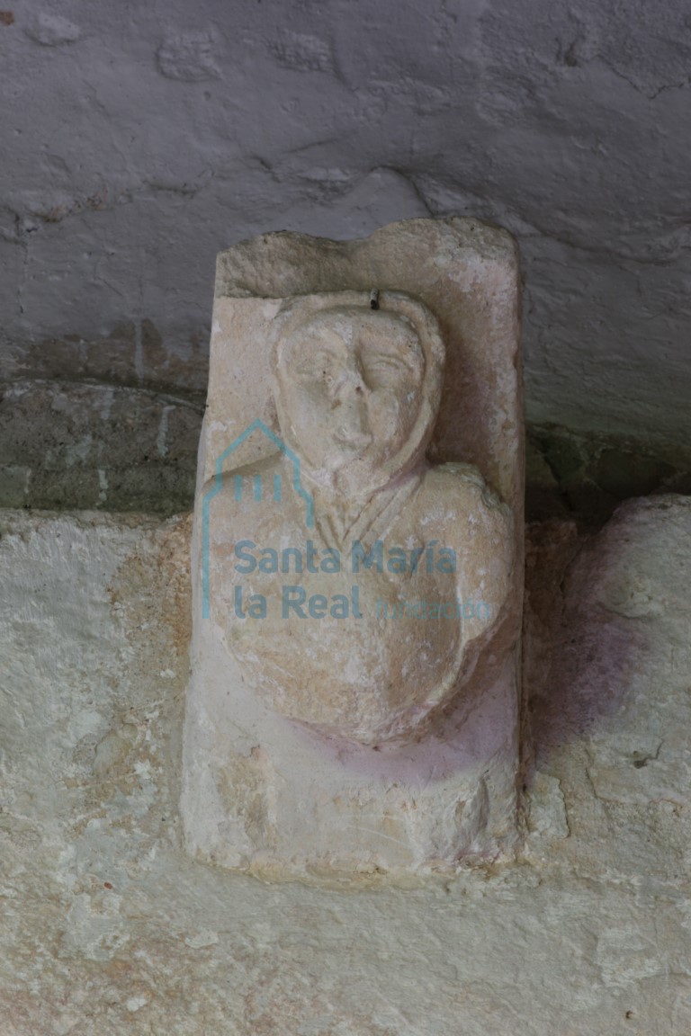 Canecillo de la portada, con fémina en estado de gestación