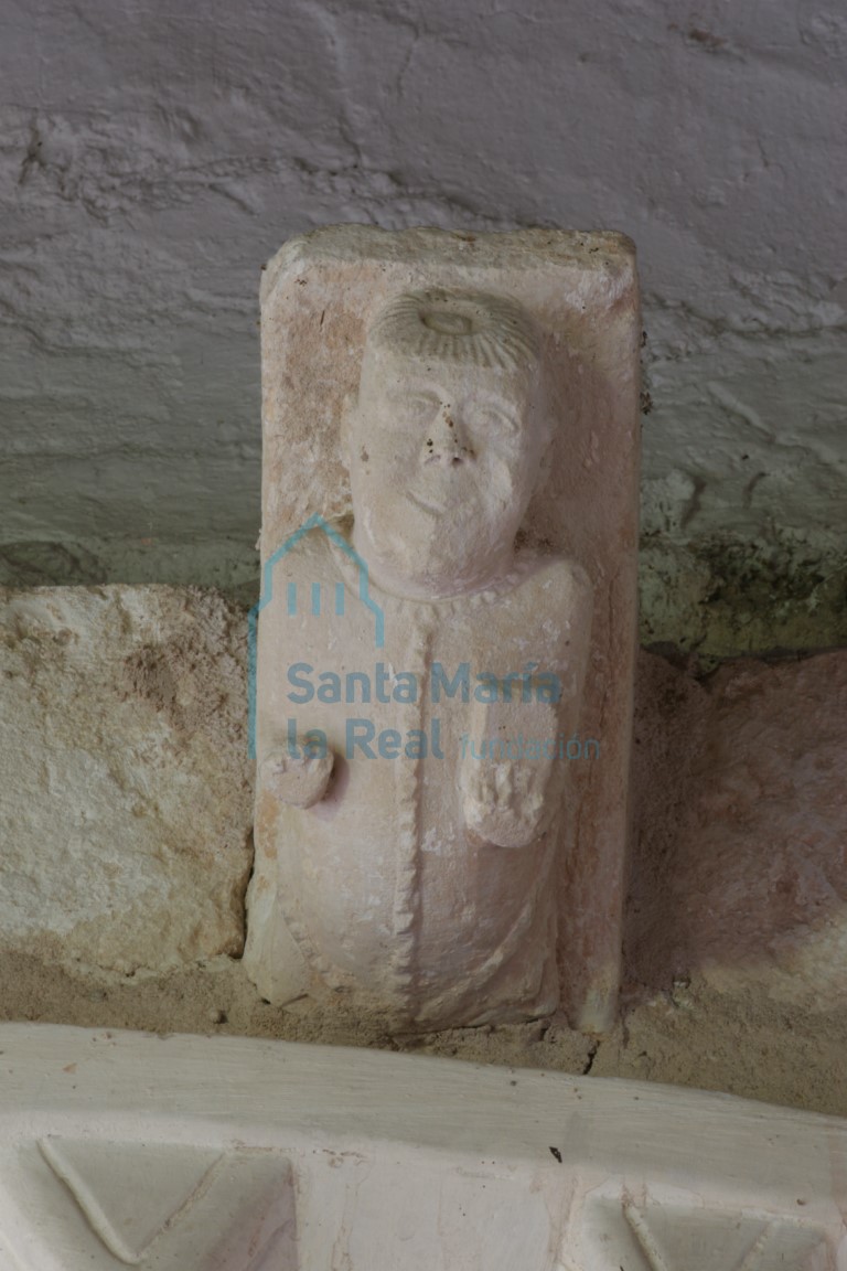 Canecillo de la portada con clérigo