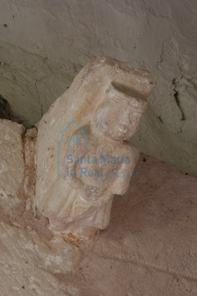 Canecillo de la portada, con figura masculina tocada con corona