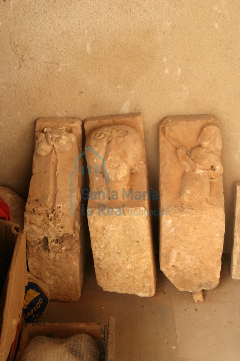 Canecillos del primitivo alero, decorados con un busto masculino, una hoja partida con caulículos en la punta y un personaje alzando una especie de maza Canecillos del primitivo alero, decorados con un busto masculino, una hoja partida con caulículos en la punta y un personaje alzando una especie de maza