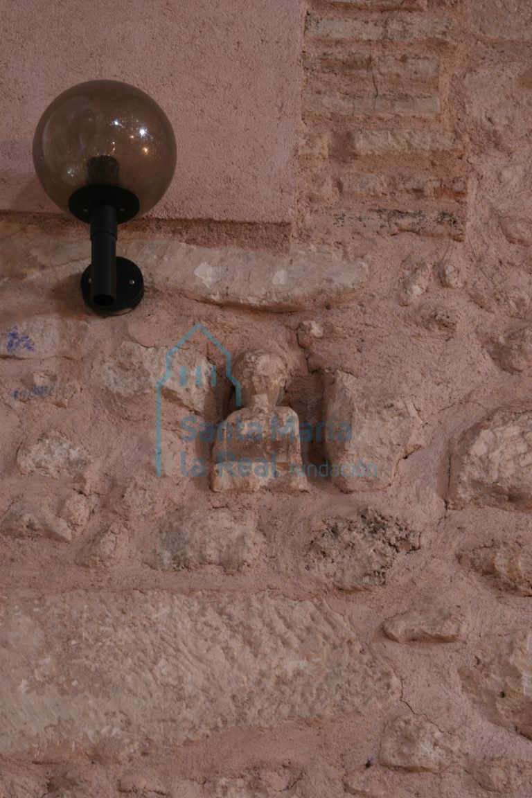 Canecillo de una figura masculina empotrado en el muro