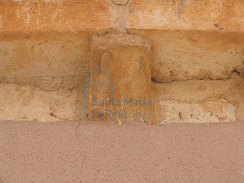Canecillo con figura humana en la cornisa del muro septentrional
