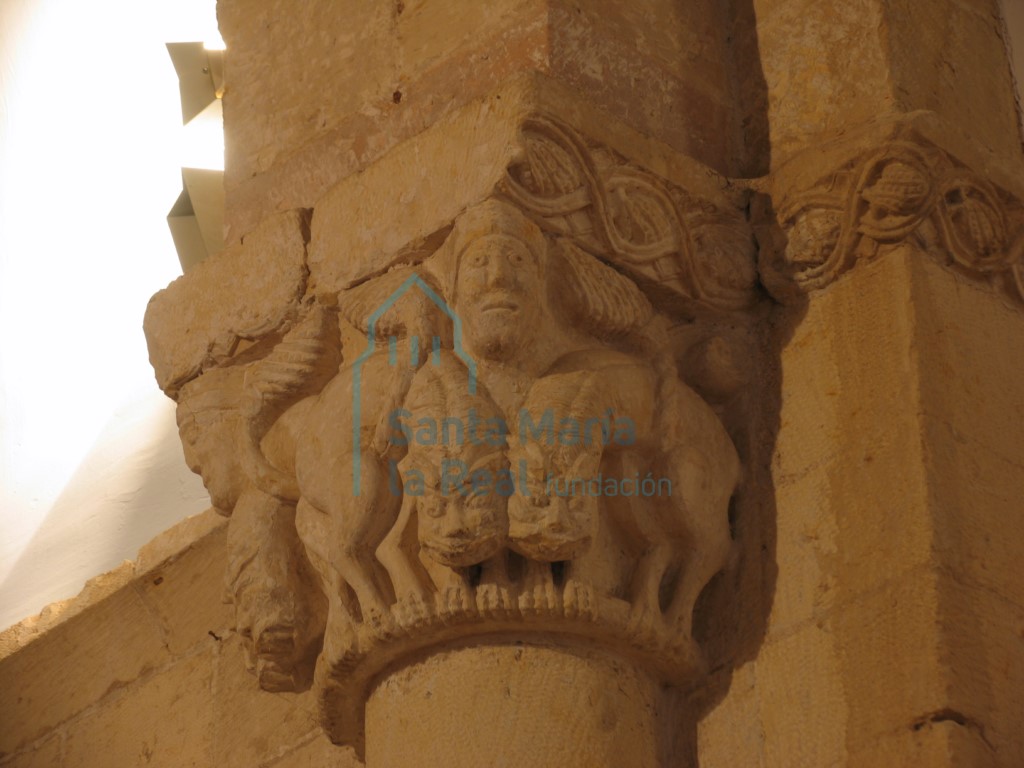 Detalle del capitel derecho del arco triunfal. Leones y cabezas con tocados en las aristas