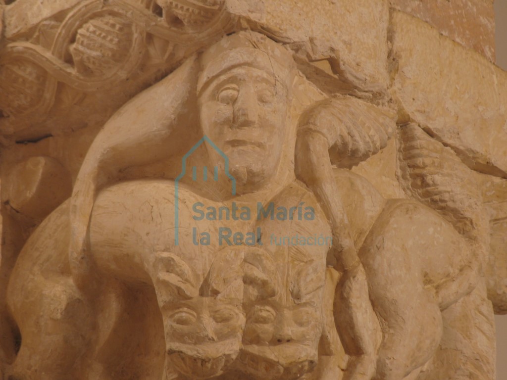 Detalle del capitel derecho del arco triunfal. Leones y cabeza con tocado en las arista