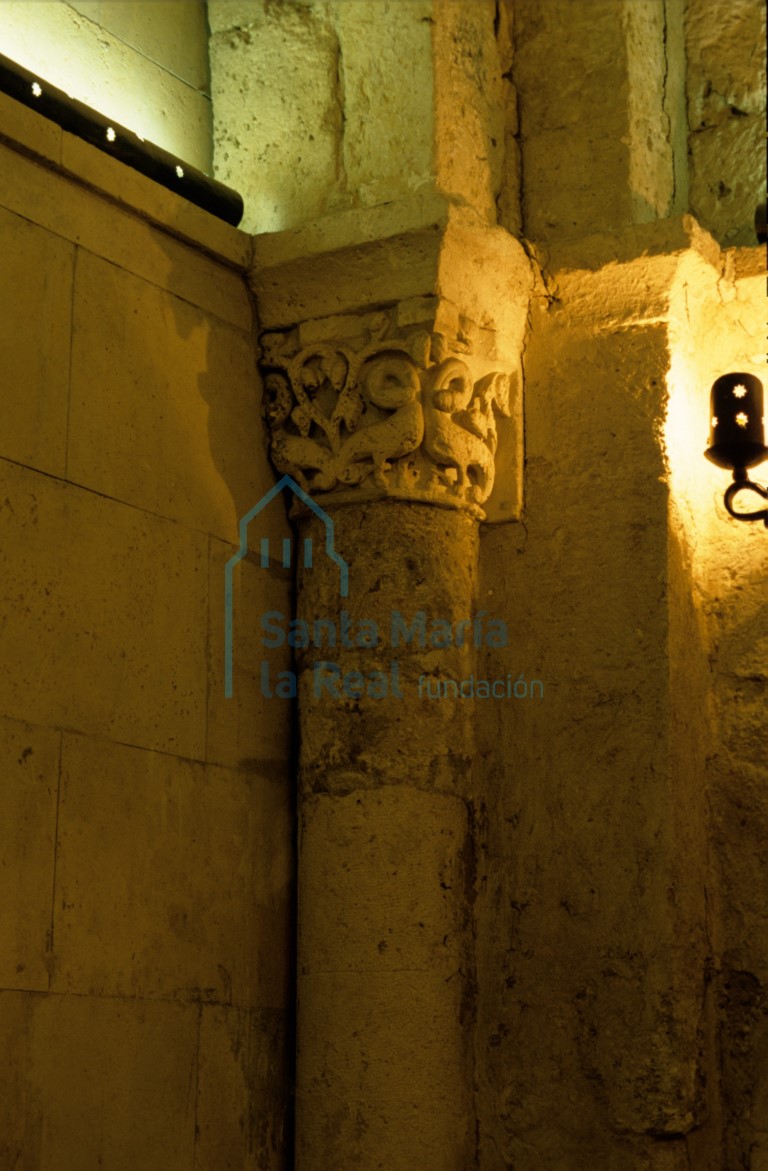 Capitel del arco triunfal. Fondo vegetal de tallos ramificados sobre el que destacan cuatro dragones que se muerden sus propios cuellos