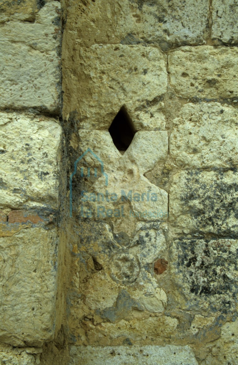 Piezas decorativas con forma de aspa empotradas en el paramento del muro norte