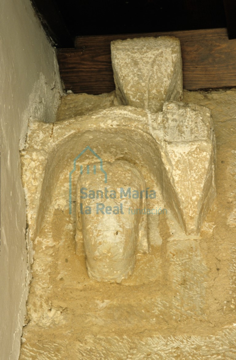 Vista frontal del relieve de cabeza masculina sobre la enjuta izquierda de la portada meridional