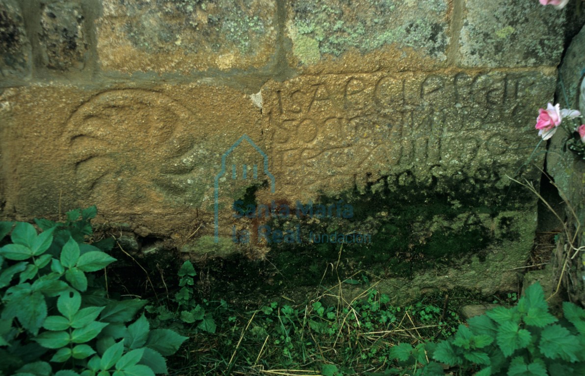 Sillares tallados con una inscripción al este de la portada románica