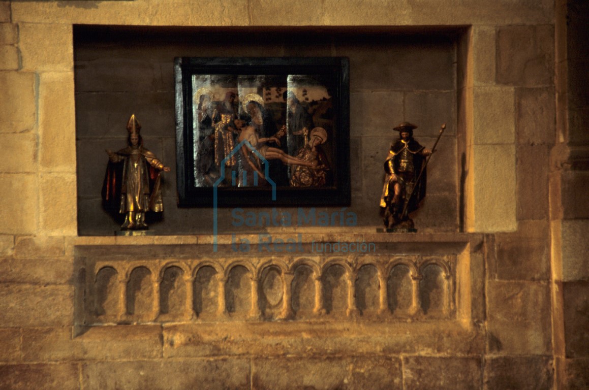 Sepulcro en el muro norte de la nave del evangelio decorado con once arcos con chambrana y en el arco central hay impronta de una mandorla almendrada