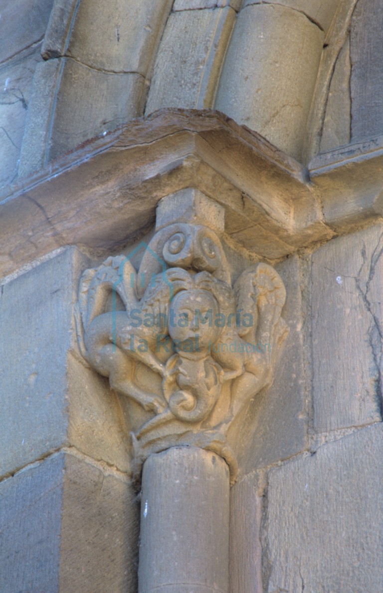 Capitel izquierdo de una de las ventanas del ábside central. Pareja de grifos picoteando la cabeza de un personaje de cuerpo serpentiforme
