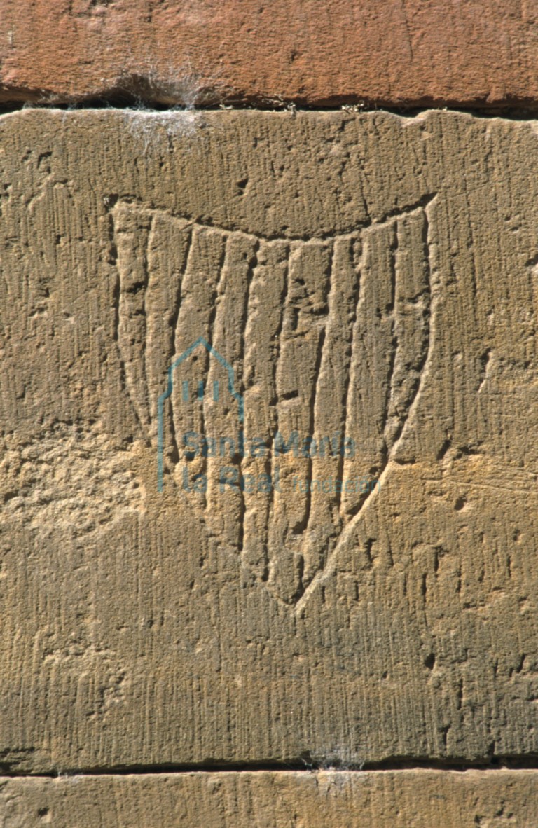 Detalle de grafito de un escudo en el exterior del tambor de la nave del evangelio