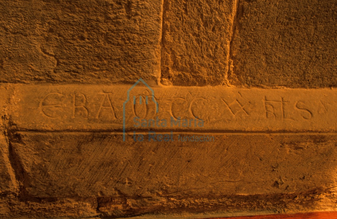 Detalle de inscripción grabada en el zócalo del pasaje que comunica la capilla mayor con el ábside del evangelio