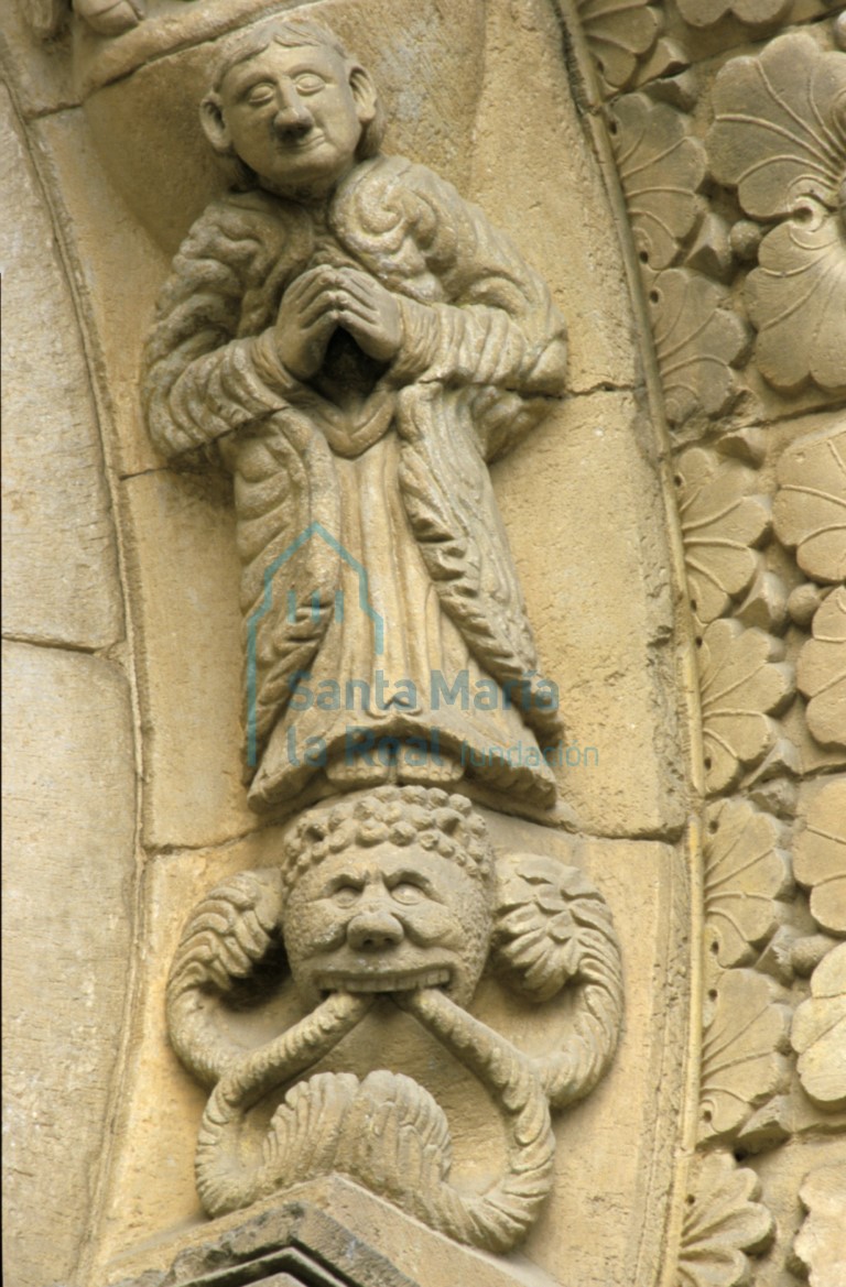 Detalle de la arquivolta interior de la portada mereidional del transepto. Figura orante de María sobre un mascarón monstruoso que vomita tallos
