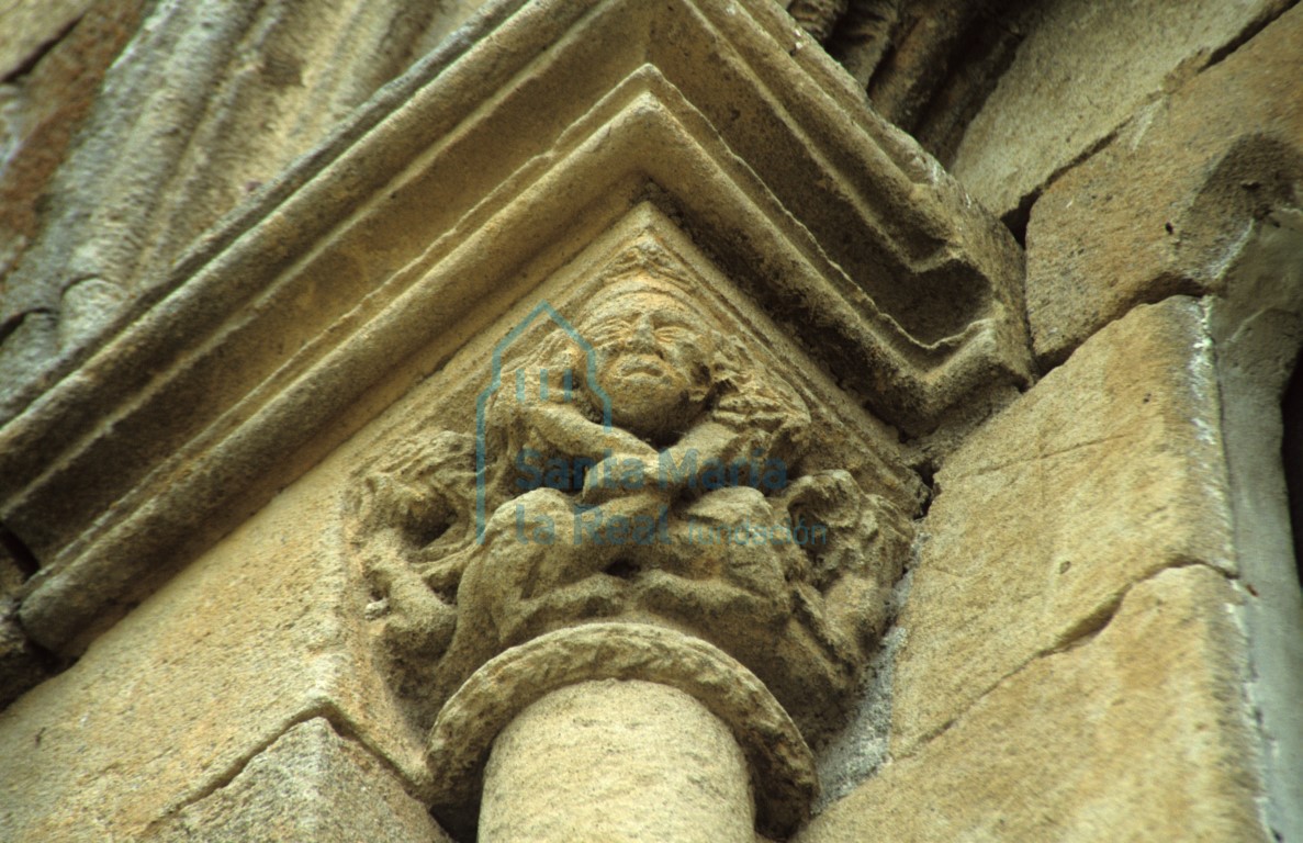 Detalle del capitel izquierdo de la ventana de la cabecera de la nave septentrional. Cabeza humana atada con serpientes con cabeza de león que azuzan diablos