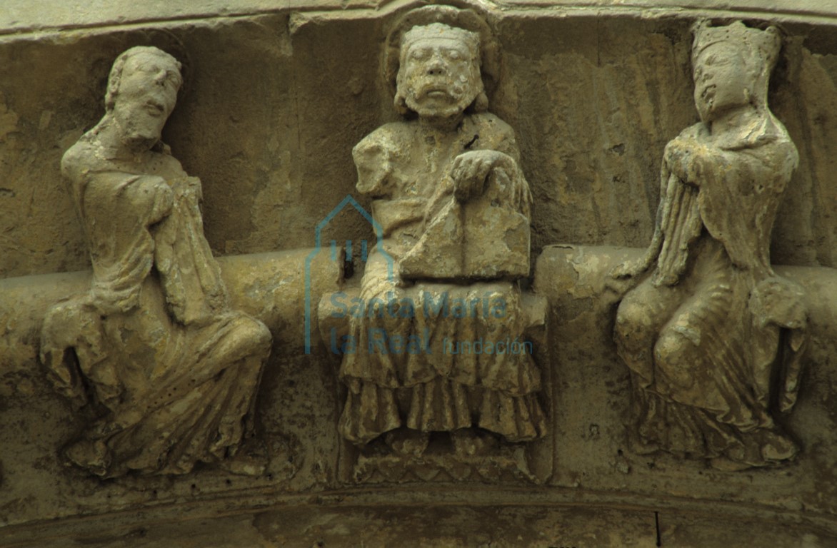 Detalle de la clave de la arquivolta exterior de la portada septentrional. Cristo bendiciendo con un libro en su mano izquierda flanqueado por la Virgen y San Juan